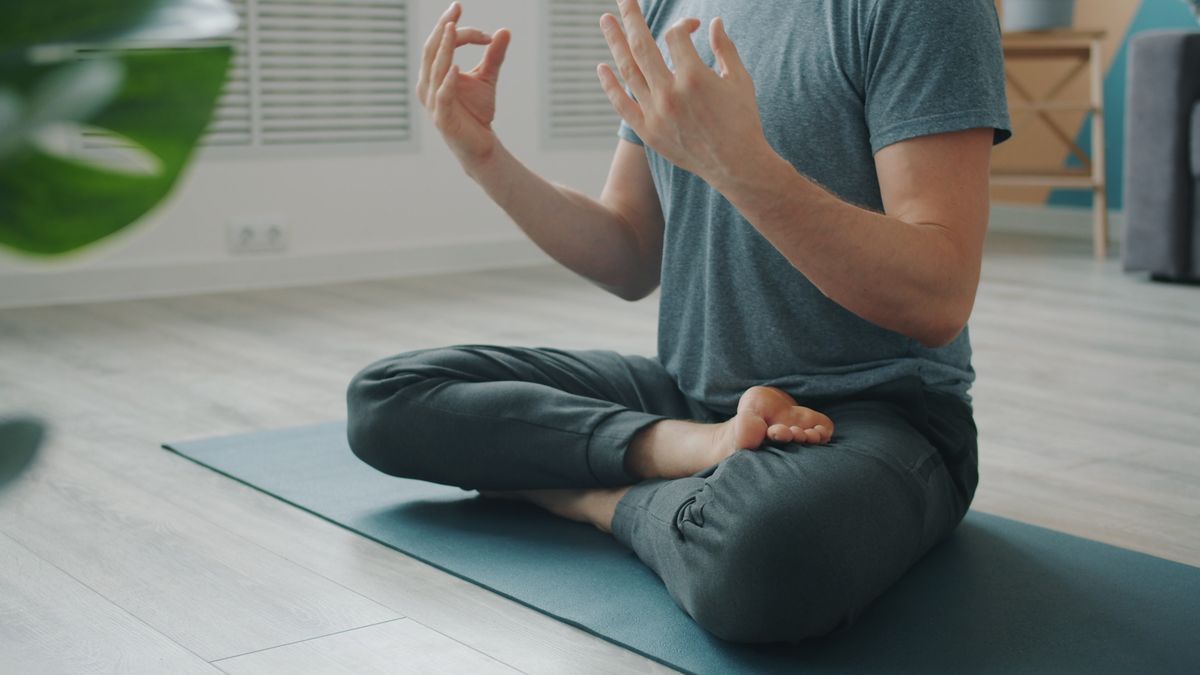 Man practicing seated box breathing meditation indoors with calm posture