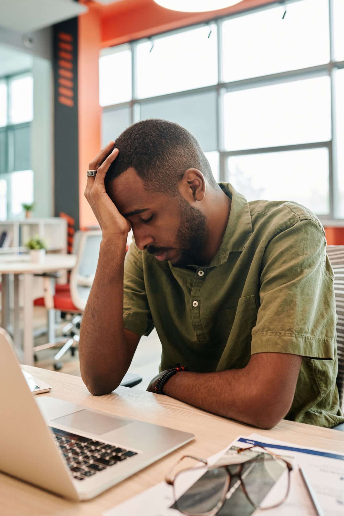 Tired man experiencing stress and burnout at office desk