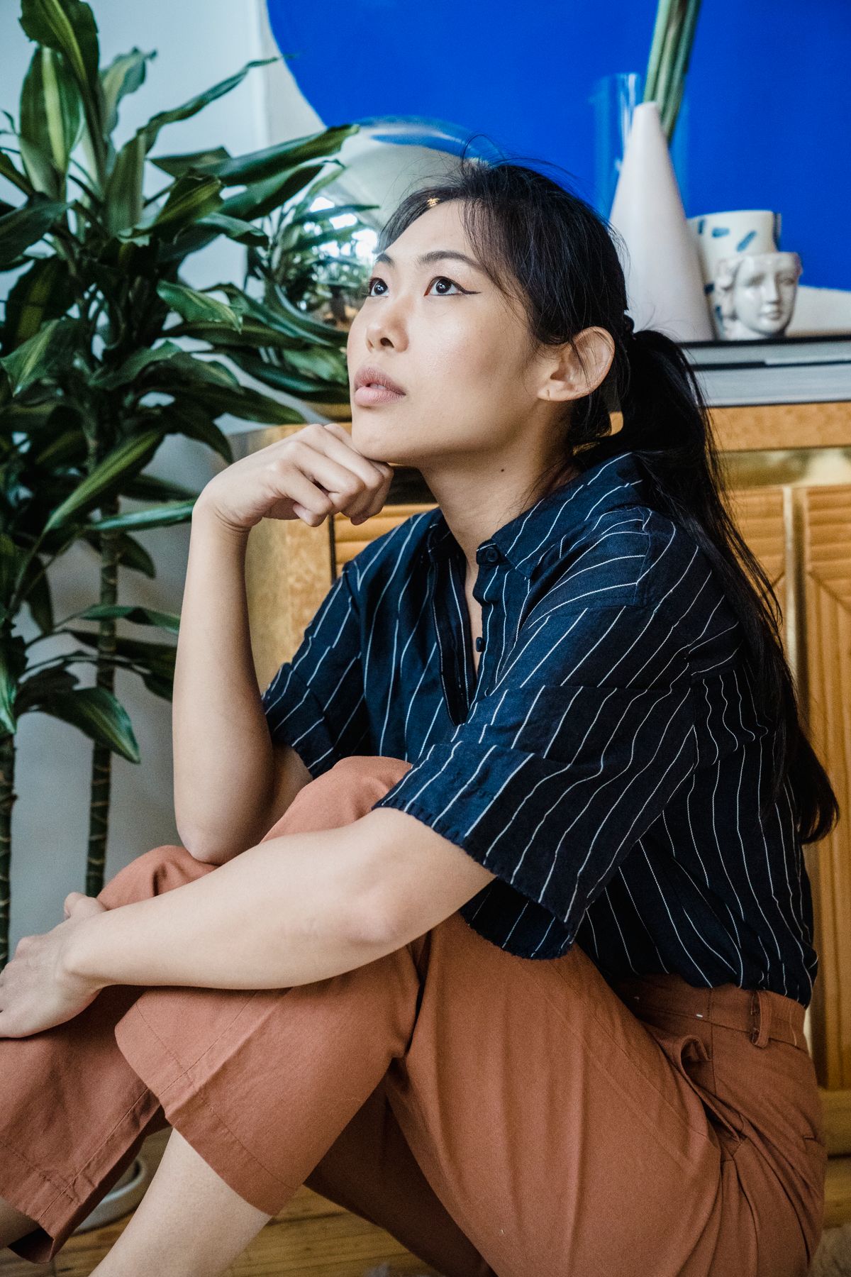 Woman sitting on floor at home in quiet contemplation before breathing exercise